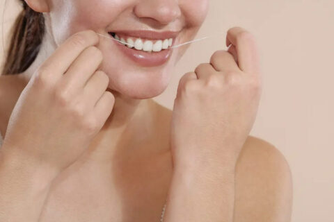 women flossing her teeth
