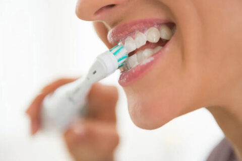 women using electric toothbrush