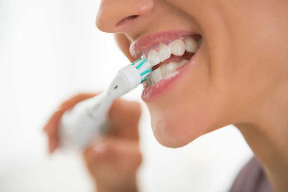 women using electric toothbrush